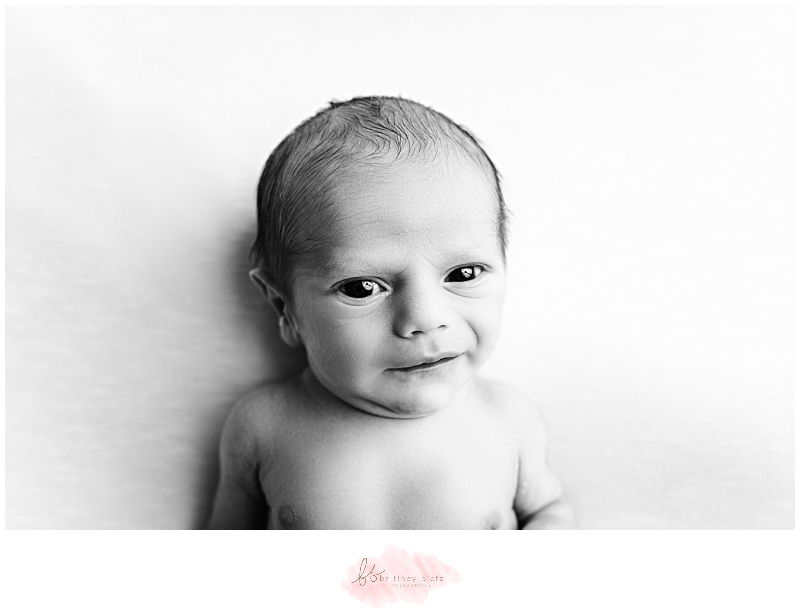 baby boy giving wide-eyed gaze to photographer